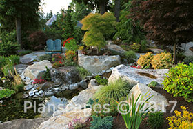 The mix of trees, shrubs, perennials and grasses enhances the hillside setting.