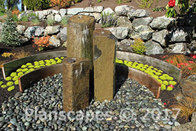 Basalt column water feature encircled by Corten steel walls inter-planted with moss.