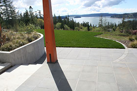 Curves in the retaining wall and a band of paving mark the pivot point between the house grid and the infinity lawn.