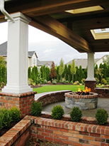 Sheltered patio by Vanessa Gardner Nagel - highlighting fire pit, raised planters, seat walls and a framed view of the garden
